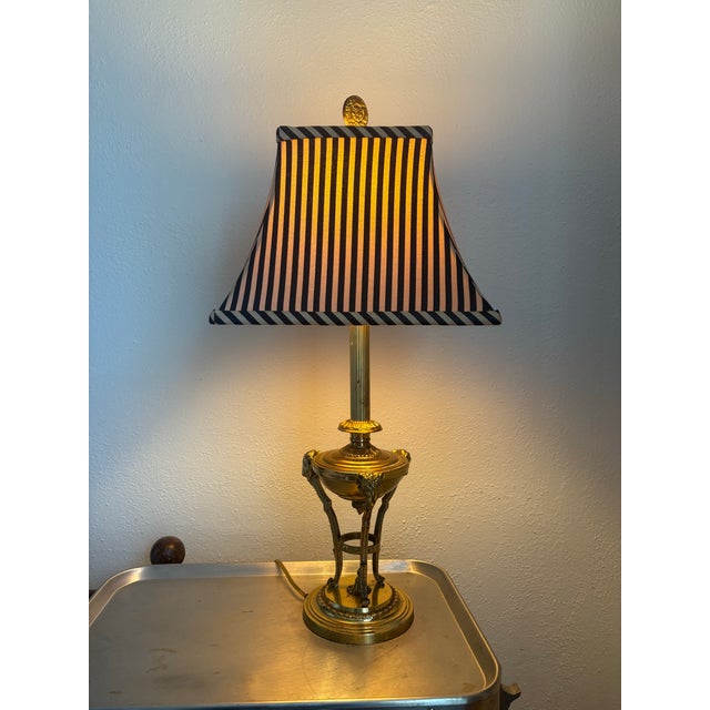 Fabulous 1960s Hollywood Regency table lamp. Brass base reminiscent of an urn with ram details, brass stem, and brass...