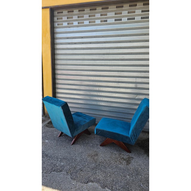 A charming pair of vintage mid-century modern armchairs, characterized by geometric lines and seats entirely upholstered...