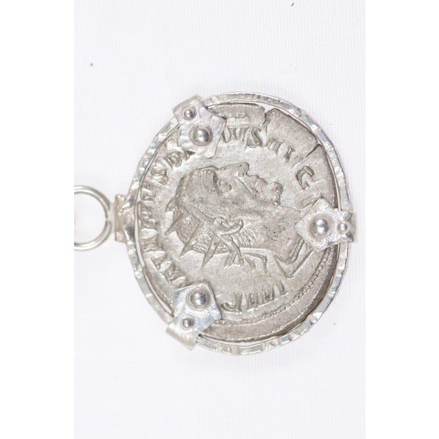 An ancient Roman Coin of Trajan Decius from 249-251 AD set with fabulous decorative silver trim accents and bail. This...