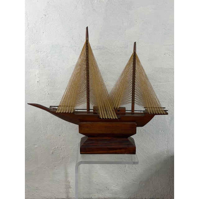This is a striking vintage handcrafted wooden model sailboat, beautifully detailed with a warm, rich wood hull and two...