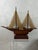 This is a striking vintage handcrafted wooden model sailboat, beautifully detailed with a warm, rich wood hull and two...