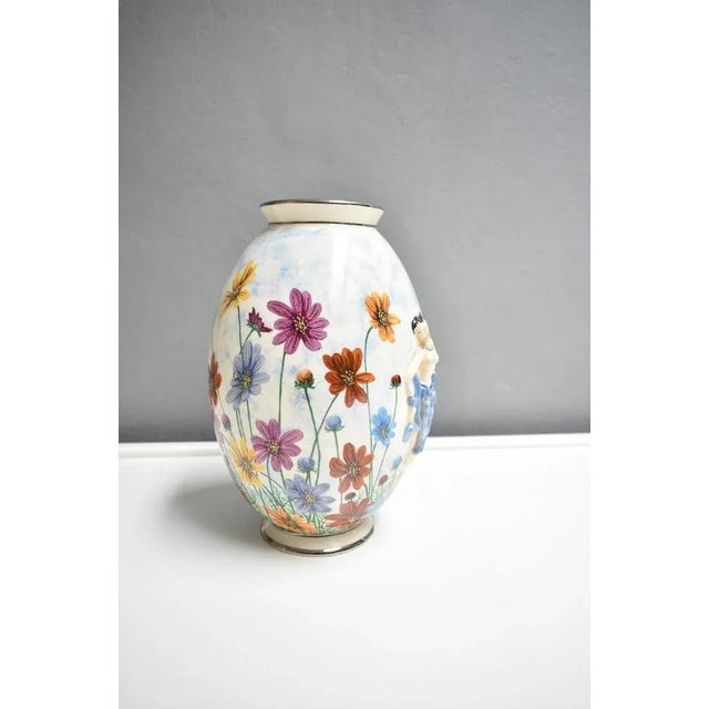 Vintage white ceramic vase with handmade floral painting. On the vase there are figures in thickness. The vase dates back...