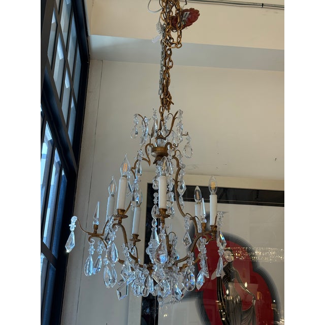 Design Plus Gallery presents a Crystal Chandelier in the Style of Dennis & Leen. The chandelier has an antique gold metal...