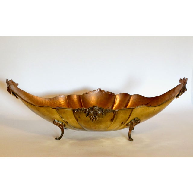 Early 20th-Century English hammered brass jardiniere or planter. It is footed and is decorated with pretty grape and fruit...
