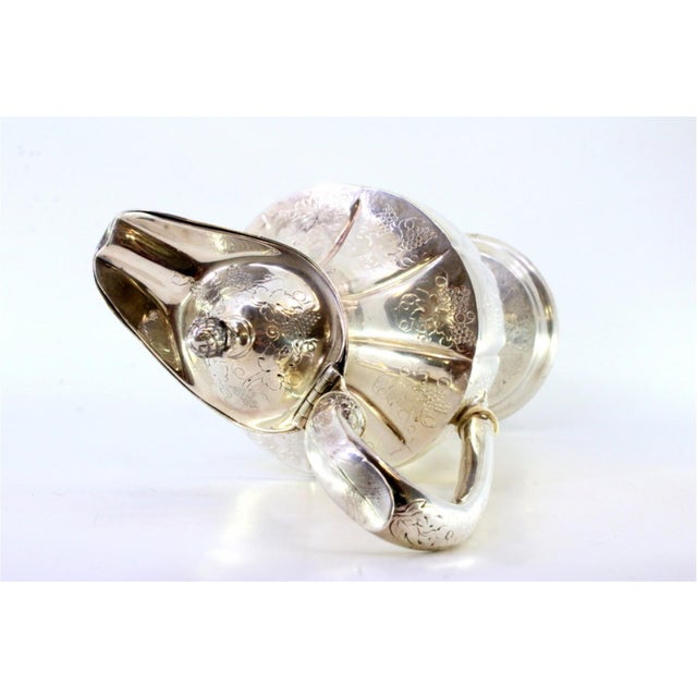 Silver Wine Jug with Engraved Wine Motifs, in Very Good conditions. Designed 1890 to 1919 This piece has an attribution...