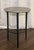A sculptural Circle Etched Accent Table by Studio A Home, a Global Views company, featuring a textured antique nickel...