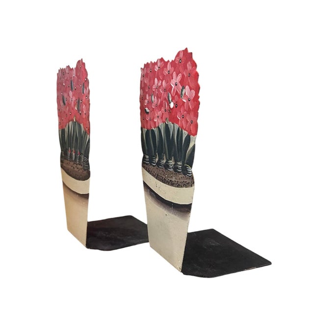 A charming, pair of tole bookends. Each features a metal bookend with hand painted, potted pink hyacinths in an aged ivory...
