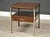 A mid century modern walnut and light brass colored aluminum nightstand designed by Paul McCobb for Calvin Collection....