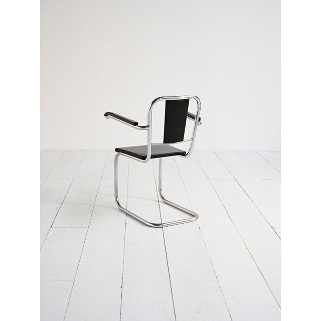 Armchair with chromed tubular steel frame and black upholstered seat and back. Cantilever design. Scandinavian production,...