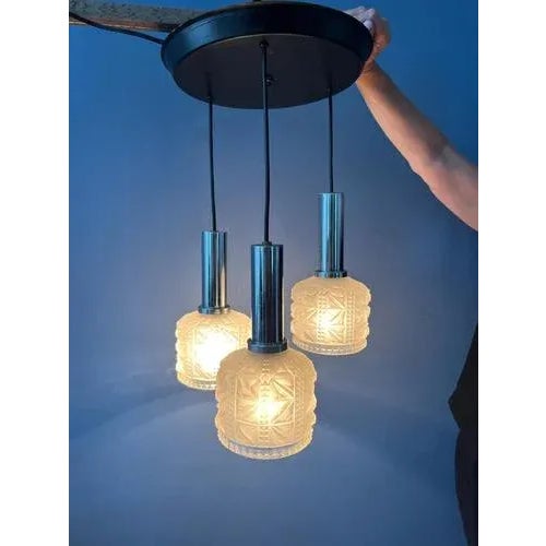 Vintage space age cascade pendant lamp with three thick glass shades. The glass shades have a frosted glass look. The...