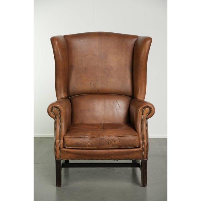 This large and luxurious sheepskin wingback chair features a beautiful, warm cognac color and a stunning patina. It is...