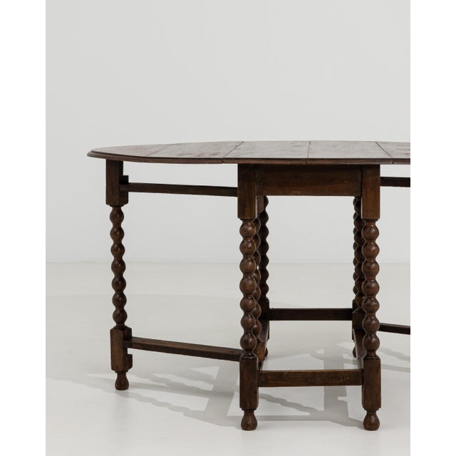 A versatile drop-leaf table featuring a folding design that allows for flexible use of space, a hallmark of 19th century...