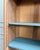 With its sculpted arched pediment, small-paned glass door, and stylized geometric ornaments, this small display cabinet...