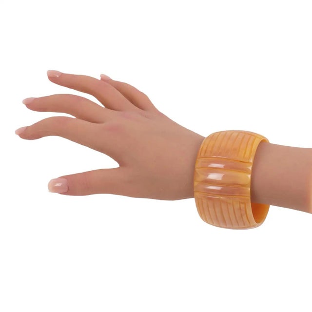 This is a stunning pink salmon blush marble Bakelite carved bracelet bangle. The bracelet features a gorgeous, important...