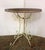 Early 20th century wrought iron bistro table. The top a woven basketry design; the apron tightly woven "reeds"; all...