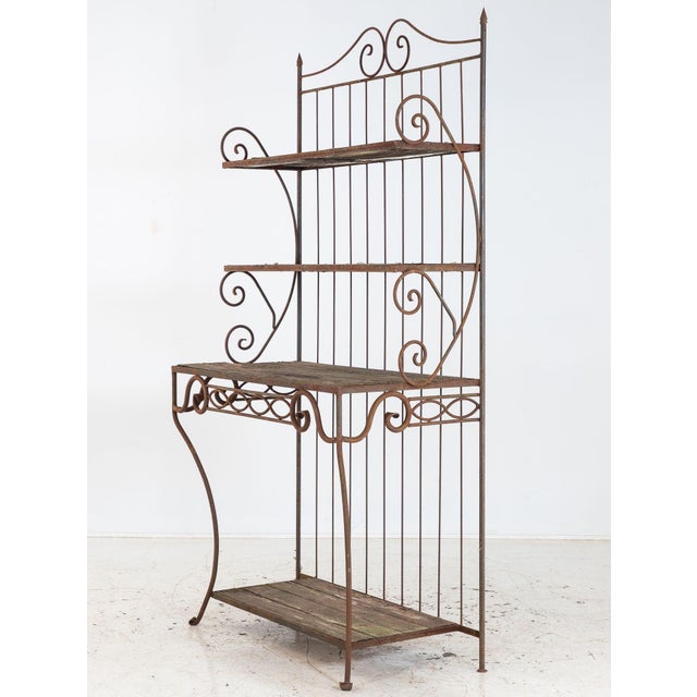 This circa 1930 French wrought iron étagère has a graceful, architectural presence defined by ascending shelves, curved...