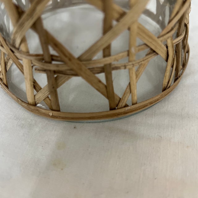 A pair of glass covered in cane hurricane globes. Mixes well with almost any style decor. Measures at the widest points 6”...