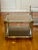 Handsome pair of 1970's two tier brass and polished steel square tables in the manner of Maison Jansen. The lower tier...