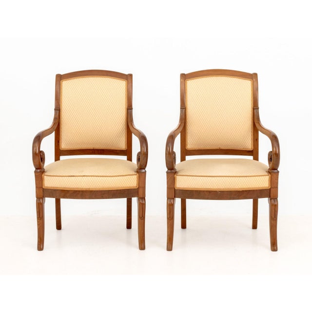 Pair of Louis Philippe Walnut Upholstered Fauteuils, 19th century, each with cream upholstery and scrolling armrests. 36"...