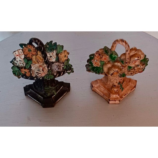 Antique Victorian cast iron doorstops with colorful painted floral bouquet motif. They will never allow the wind to move...