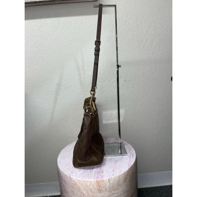 The Louis Vuitton Leather & Suede Shoulder Bag is a refined blend of texture, craftsmanship, and timeless style. Expertly...