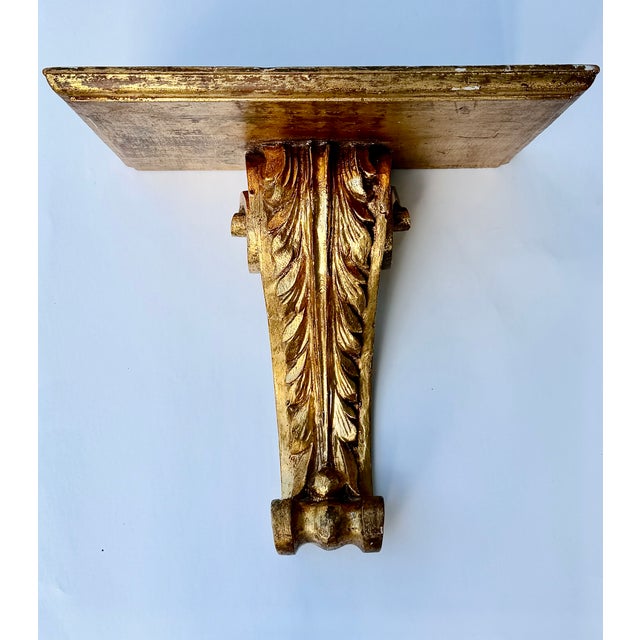 A large giltwood wall bracket shelf in the neoclassical style. Its square top is supported by a carved acanthus leaf that...