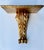 A large giltwood wall bracket shelf in the neoclassical style. Its square top is supported by a carved acanthus leaf that...