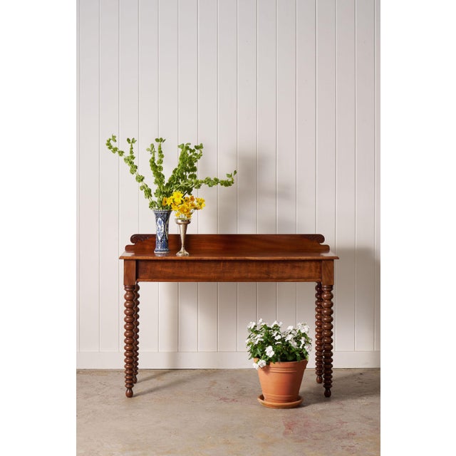 Striking Victorian mahogany console featuring classic bobbin legs, rich patina, and generous scale—perfect for entryways,...