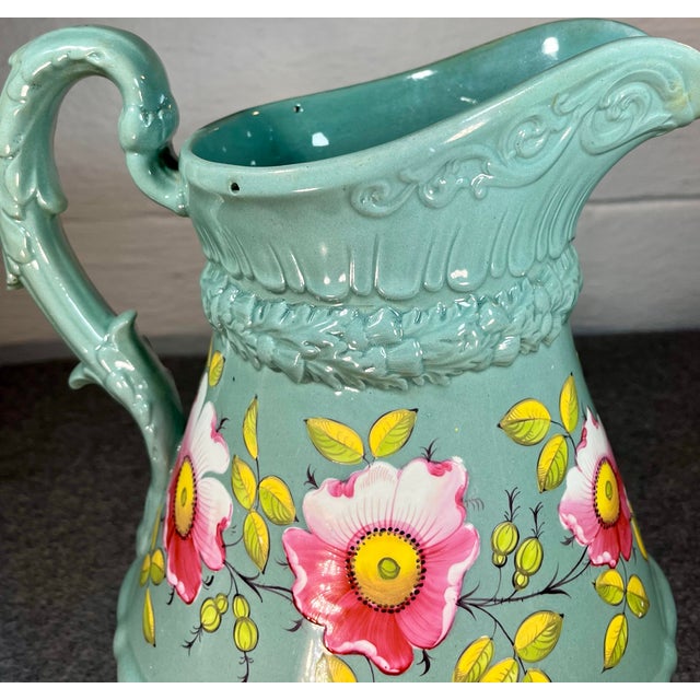 Large antique jug in a lovely blue gray color with a pink floral design and decorative handle. *Former property of the...