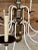 A fabulous vintage twelve-light chandelier featuring a dramatic spray of sculptural brass-tone tole palm leaves above...