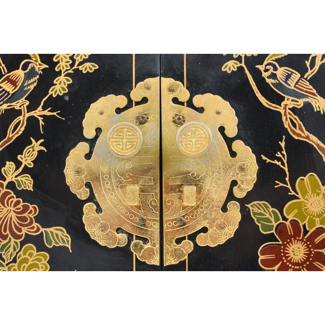 Vintage Chinoiserie cabinet painted with a black gloss lacquer with hand painted nature motifs on each side. It features...