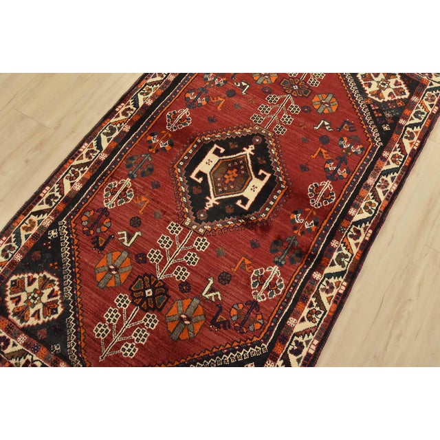 An authentic vintage tribal Shiraz rug hand-knotted with fine wool and natural dyes. This nomadic rug features a geometric...