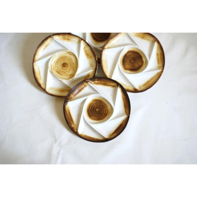 A set of 5 ceramic plates by Longchamp France. Stunning geometric brown and beige design with a central spiral motif,...