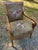 A pair of French Empire style Arm chairs upholstered in an olive velvet emblazoned with heraldic crests on the seats and...