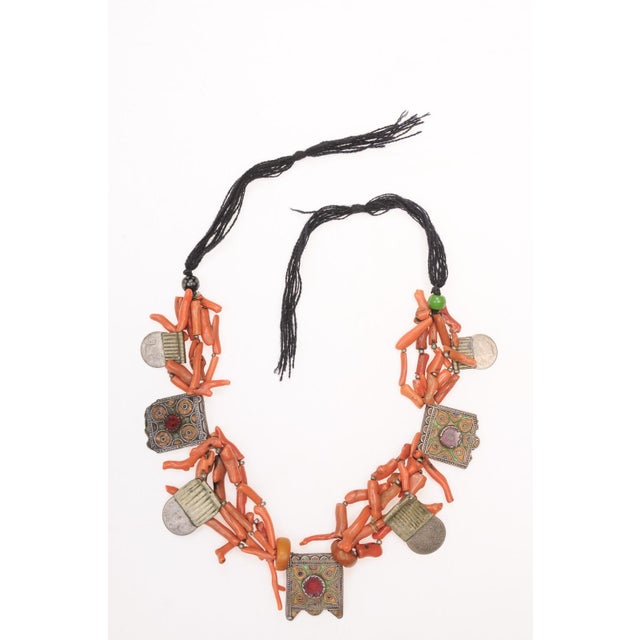 A spectacular hand beaded antique coral and metal beaded Moroccan necklace from the early 20th Century. Loose clusters of...
