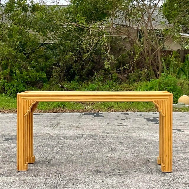 A stunning vintage Coastal pretzel rattan console table. A gorgeous Ming shape with updated fretwork detail. A fabulous...