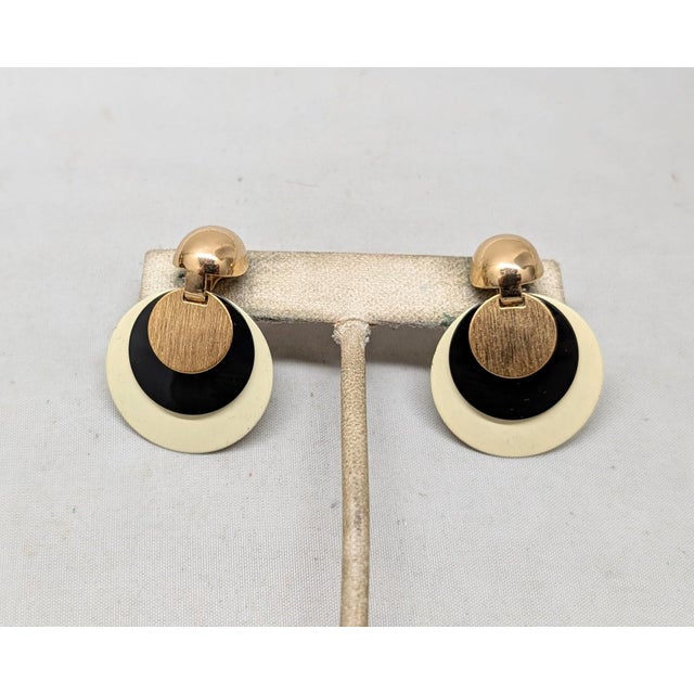 1970s oval domed top with off-white round disc drop with smaller black round disc on top of that and smaller textured...