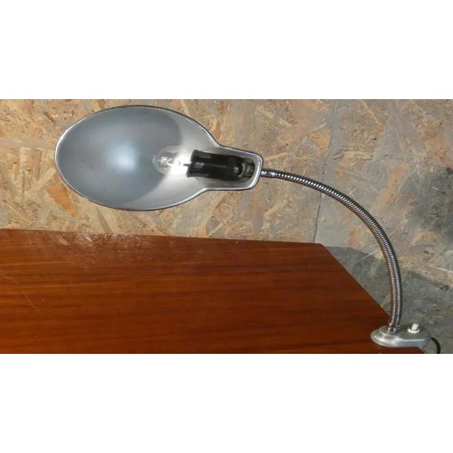 Industrial lamp with articulated arm and clamp at the base produced by the historic company "A. Perazzone To." The lamp is...