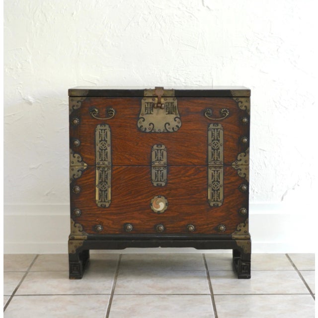 Stunning Mid-Century Asian inspired wood campaign side table with brass decorations, circa 1950s. This striking artisan...