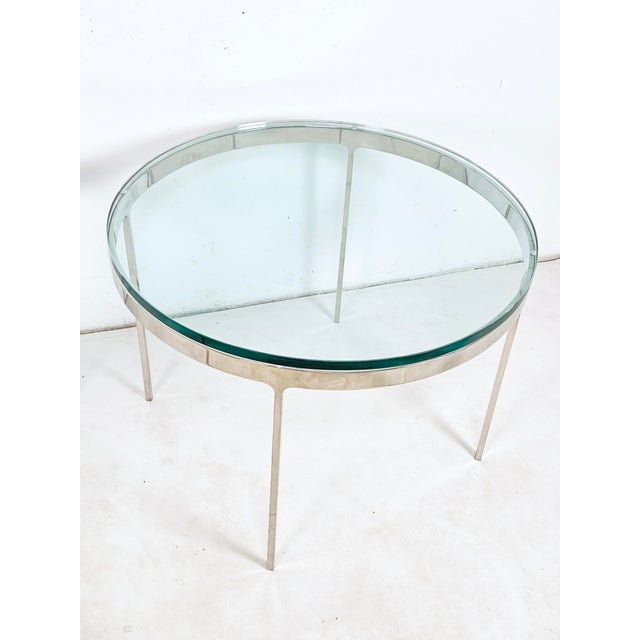 A pair of side tables in solid stainless steel with thick glass tops circa 1970s by the Greek born industrial designer and...