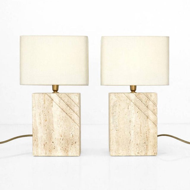 Pair of rectangular table lamps in solid travertine, characterized by a sculpted decoration of diagonal grooves on the...
