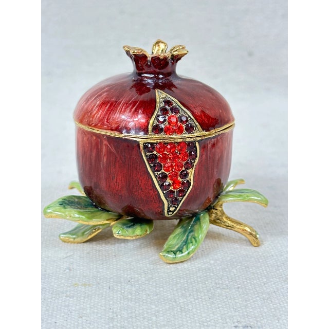 A beautiful pomegranate spice box hand painted in a rich red and featuring red crystals to represent the fruit's seeds....