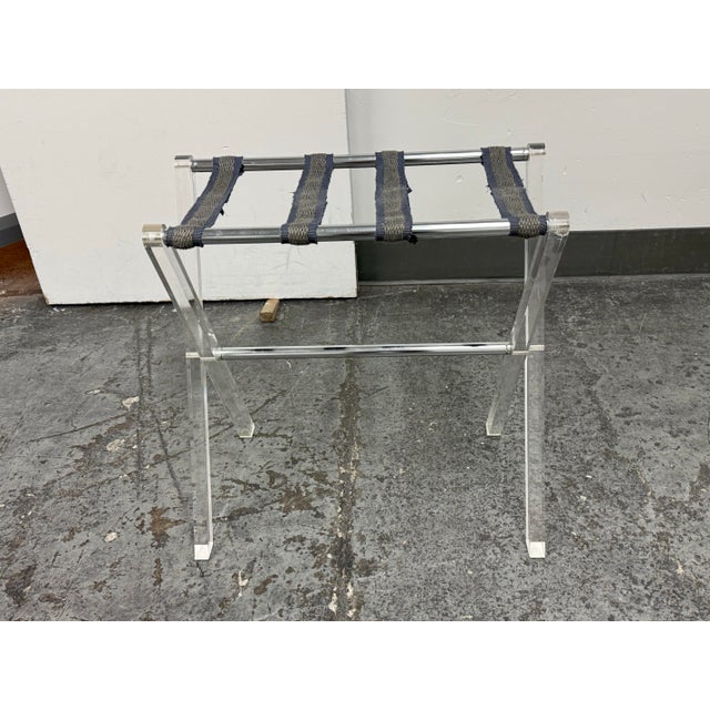 Design Plus Gallery presents a Butler Acrylic Folding Luggage Rack. This folding luggage rack has a transparent acrylic...