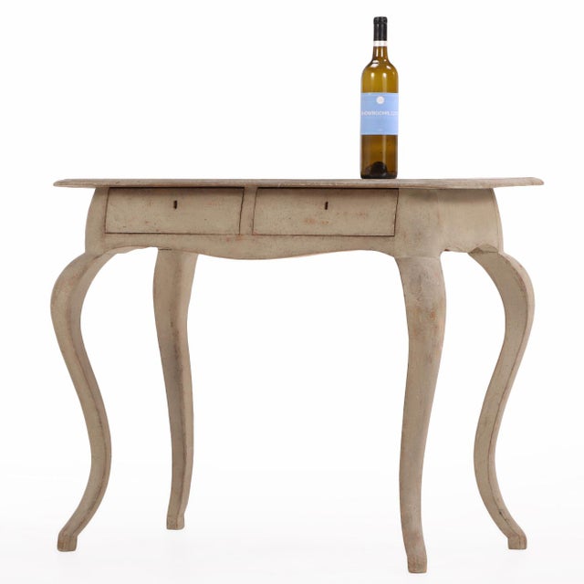 Charming Swedish painted pine console or writing desk featuring a molded rectangular top above two frieze drawers. Raised...