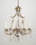 French style chandelier with a gold leaf wrought iron frame, rock crystal teardrops and crystal rosettes and leaves. The...
