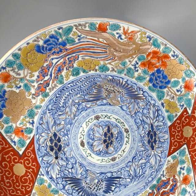 A brightly colored large charger. Japanese porcelain charger, c. 1850. The border is decorated with large gilt Japanese...