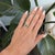 A natural tsavorite garnet from Tanzania glows green in a marquise silhouette, framed by diamonds in this estate-style...