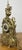 A striking Vintage French brass clock with an exceptionally ornate design, featuring intricate scrollwork, decorative cast...
