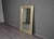 A large rectangular mirror set in a wide frame clad in stamped tin, pressed with an alternating pattern of raised and...