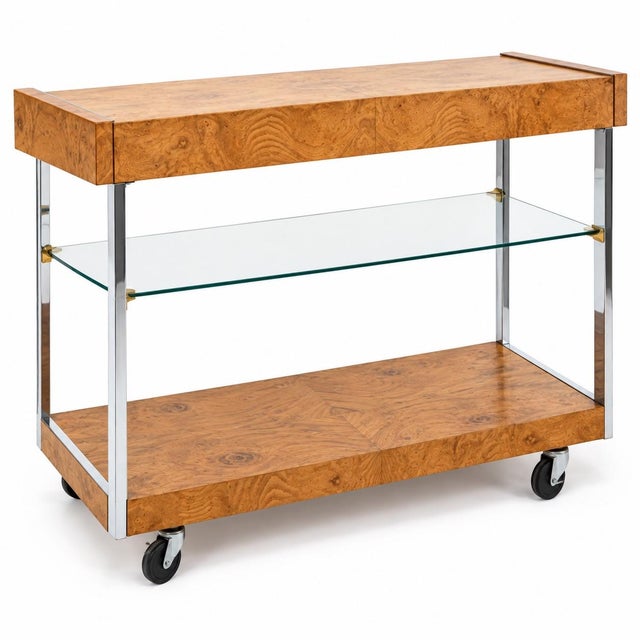 This is a 1970s modern extendable burl olive wood bar cart with chrome supports attributed to designer Milo Baughman for...